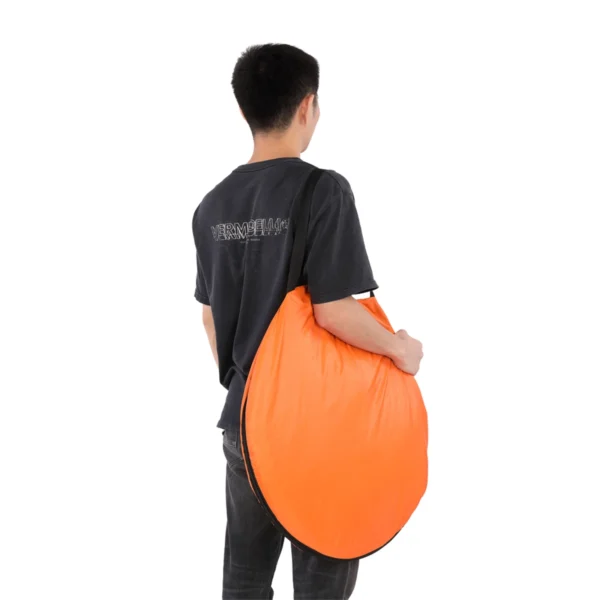 Man carrying orange pop up tent.