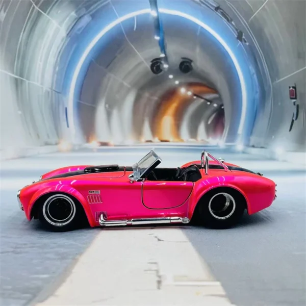 Pink Cobra sports car model in tunnel.