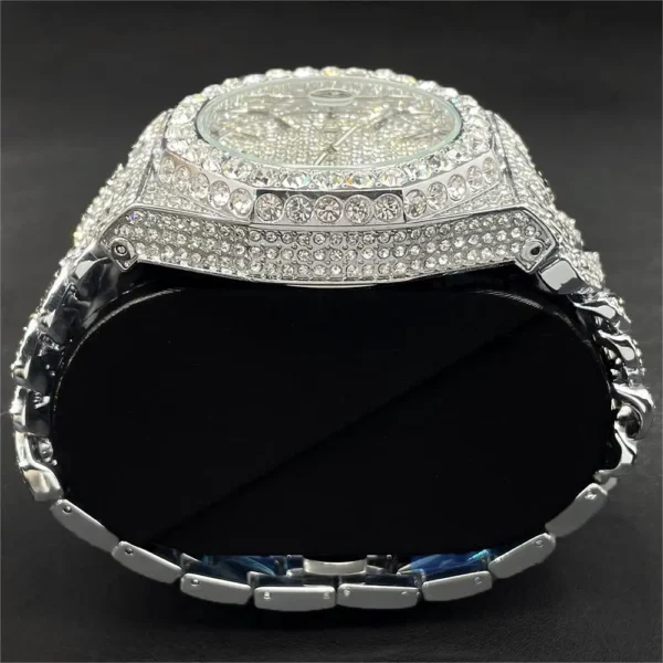 Diamond encrusted silver watch on stand.