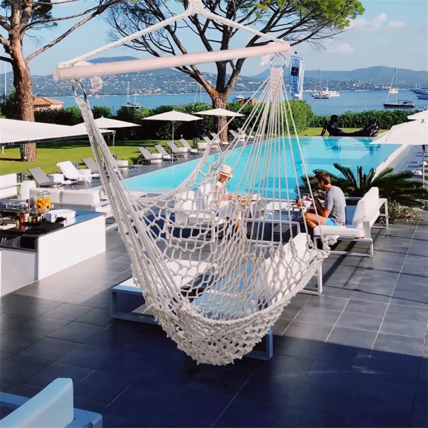 White hammock hanging over pool deck.