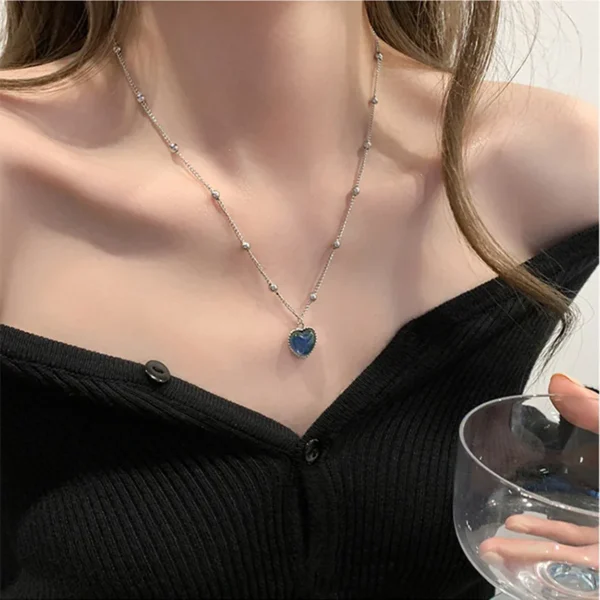 Silver chain with blue heart pendant.