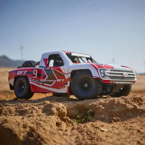 White and red off-road truck on sand.