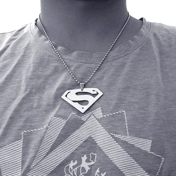 A silver Superman necklace on a man.