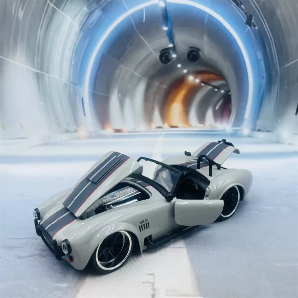 Gray toy car with hood open in tunnel.