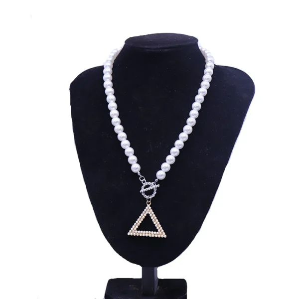 White pearl necklace with triangle pendant.