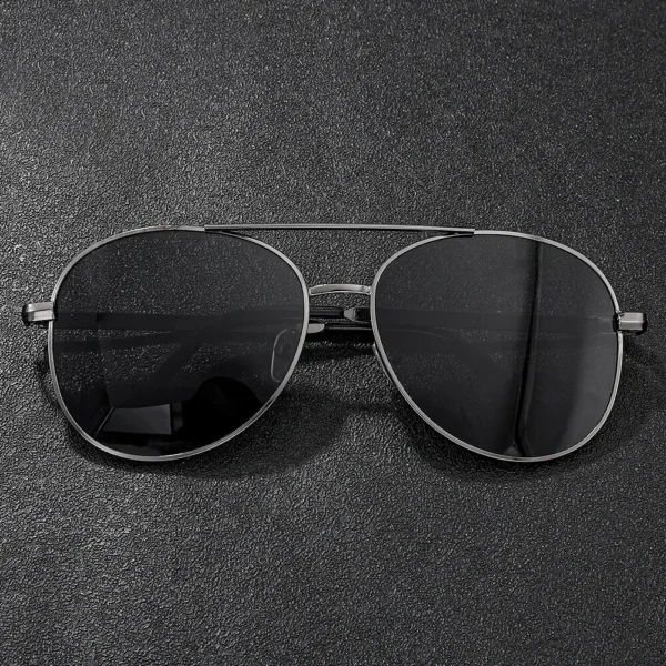 Black aviator sunglasses on black surface.