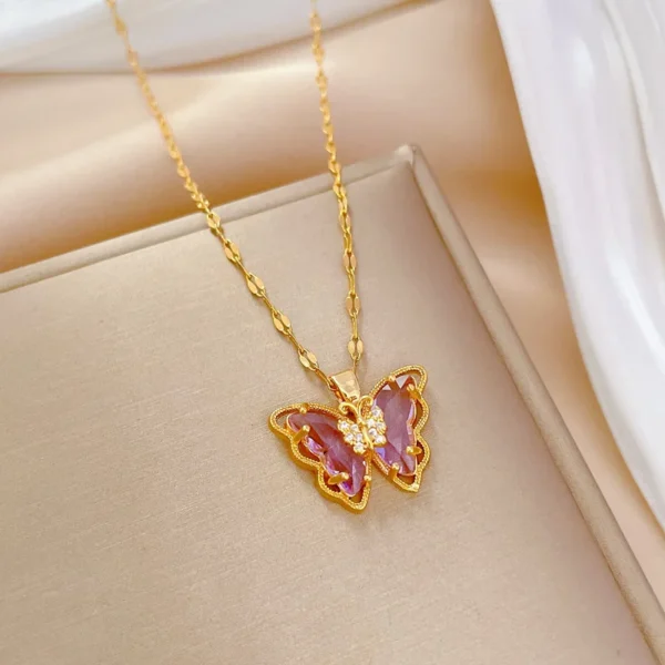 Gold butterfly necklace with purple gem.