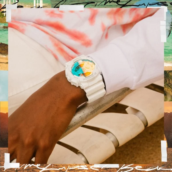 White G-Shock watch on a wrist at the beach.