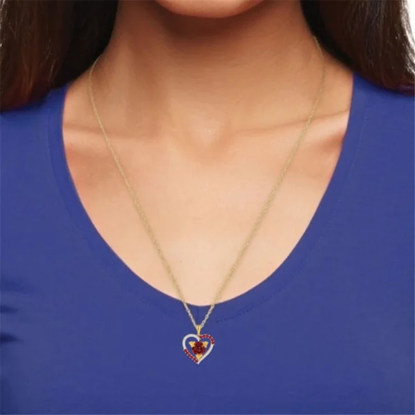 Woman wearing a gold rose heart necklace.